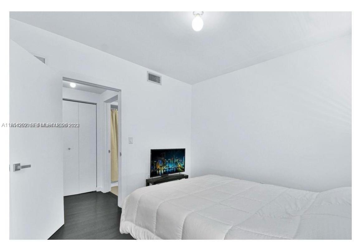 557 Michigan Avenue, Unit 111 Miami Beach, FL 33139 - Photo 10 of 13 a bedroom with a bed and a fireplace