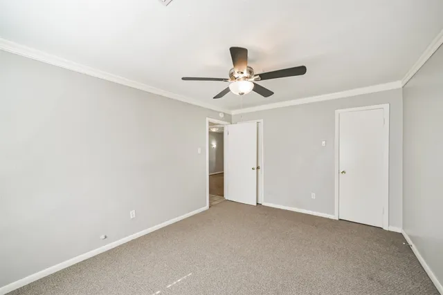 an empty room with a window and a ceiling fan