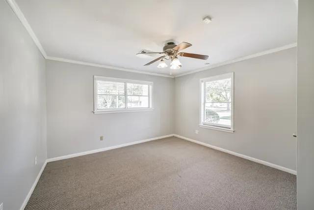 an empty room with a window and a ceiling fan
