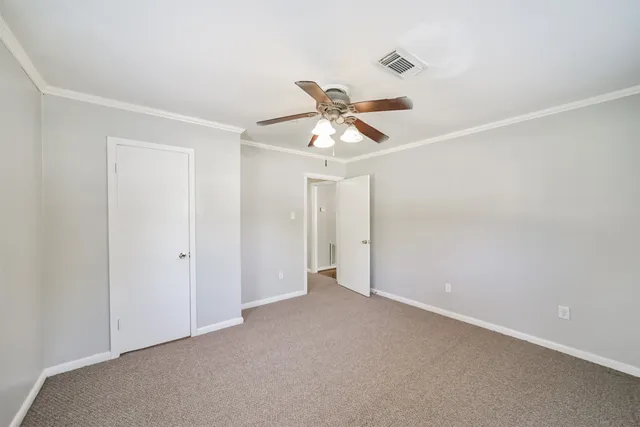 a view of a room with a ceiling fan and a window