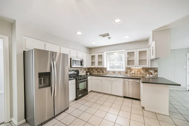 a kitchen with a sink and stove top oven