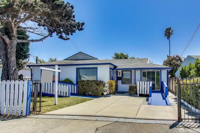 a view of house with a yard and potted plants