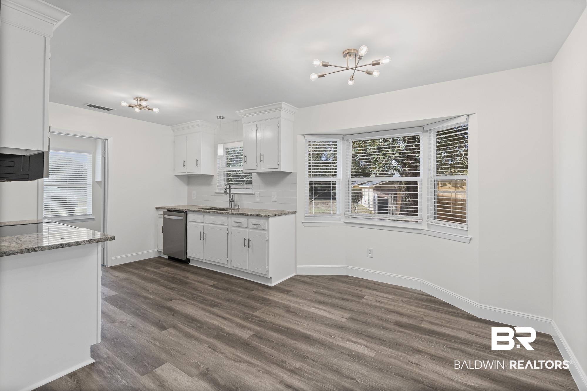 3041 Pretty Branch Drive East Mobile, AL 36618 - Photo 8 of 20 Kitchen with white cabinetry, light stone countertops, a chandelier, dark wood-type flooring, and dishwasher