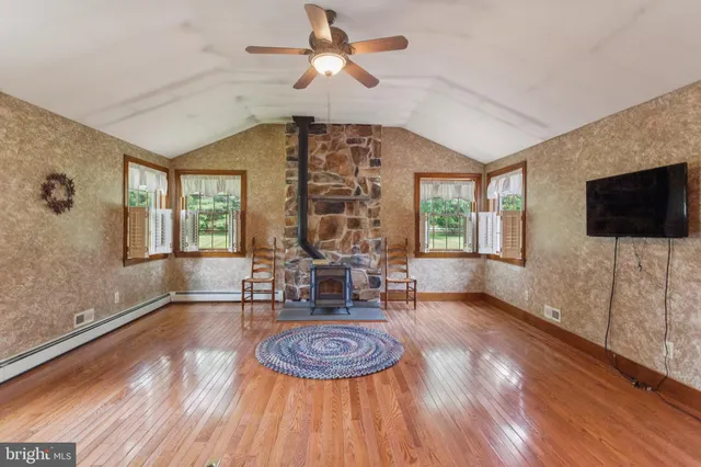 a living room with furniture a flat screen tv and a large window
