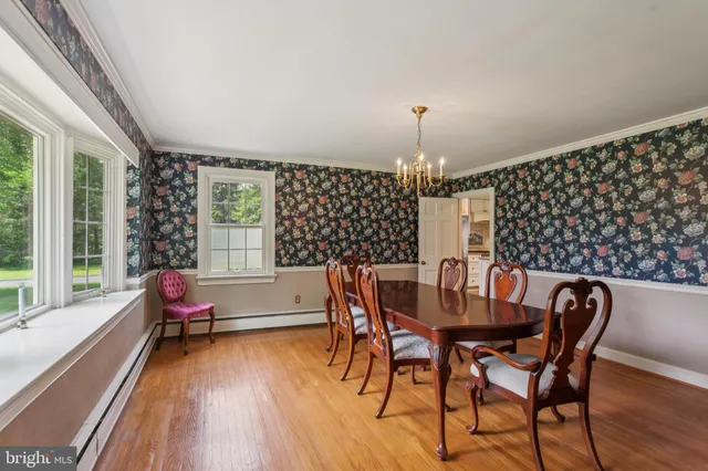 a dining room with furniture a chandelier and wooden floor