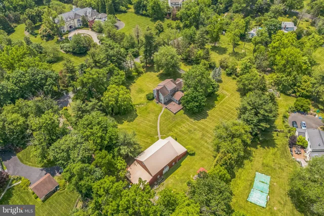 an aerial view of a residential houses with yard
