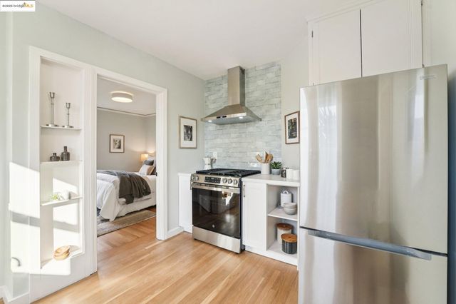 a kitchen with stainless steel appliances granite countertop a refrigerator and a stove top oven