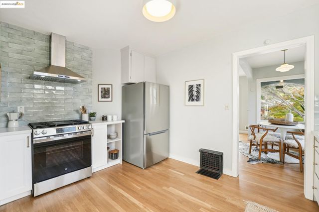 a kitchen with stainless steel appliances granite countertop a stove a refrigerator and a fireplace