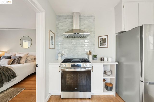 a kitchen with a stove top oven and refrigerator