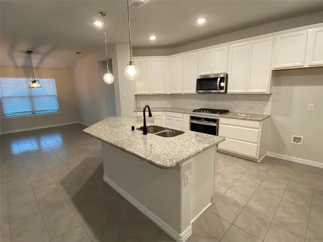 a kitchen with stainless steel appliances granite countertop a sink and a stove