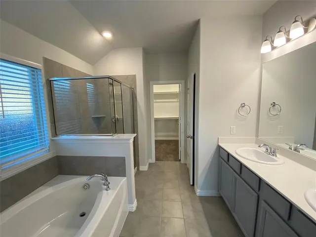 a spacious bathroom with a tub sink shower and mirror