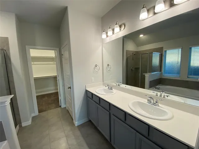 a bathroom with double vanity and a mirror