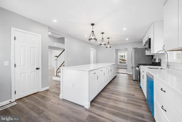 a large white kitchen with wooden floors and white walls