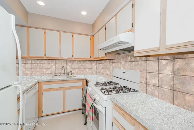 a kitchen with a sink stove top oven and cabinets