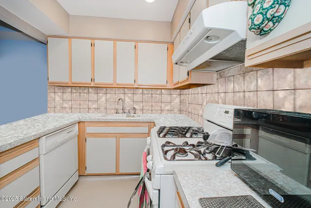 a kitchen with a sink a stove and cabinets