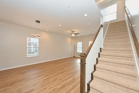 a kitchen with stainless steel appliances granite countertop a refrigerator a stove top oven a sink dishwasher and white cabinets with wooden floor