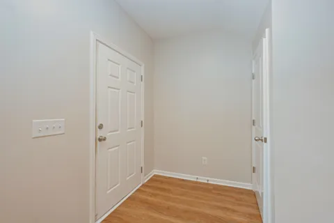 a view of a room with wooden floor and ceiling fan