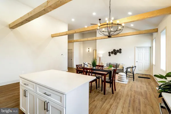 a kitchen with a table chairs and wooden floor