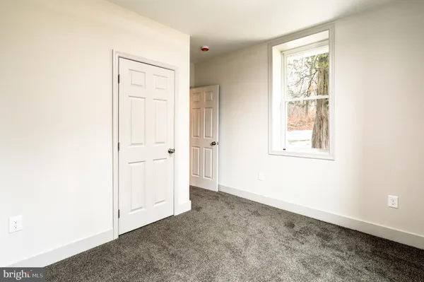 an empty room with windows and closet
