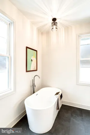 a bathroom with a white tub and a window