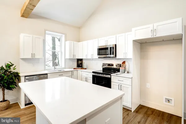 a kitchen with a refrigerator a stove a microwave a sink and cabinets