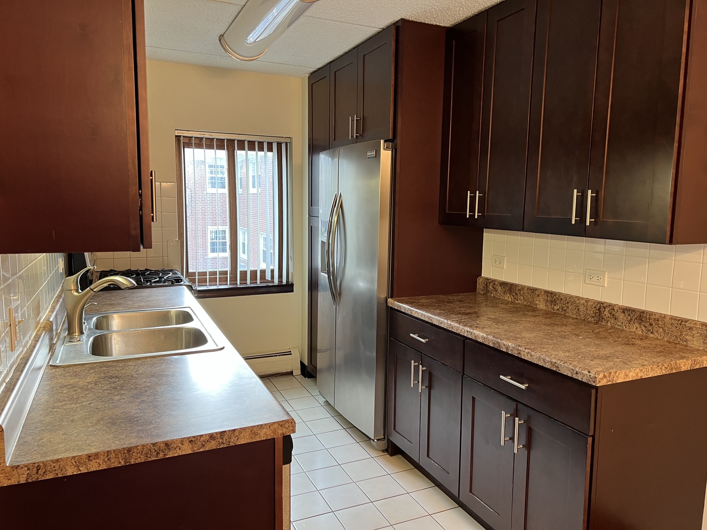 835 Pearson Street, Unit 209 Des Plaines, IL 60016 - Photo 5 of 10 a kitchen with kitchen island a counter top space a sink and cabinets