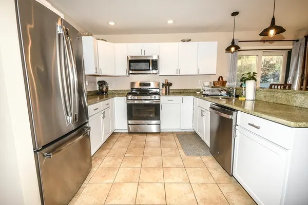 a kitchen with white cabinets and appliances