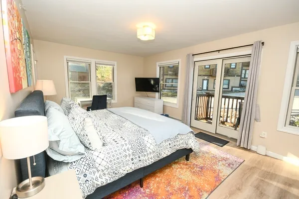 a spacious bedroom with a bed and a flat screen tv