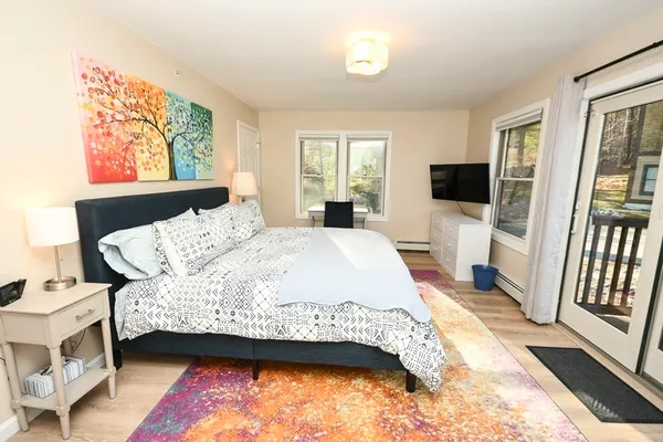 a bedroom with a bed wooden floor and window