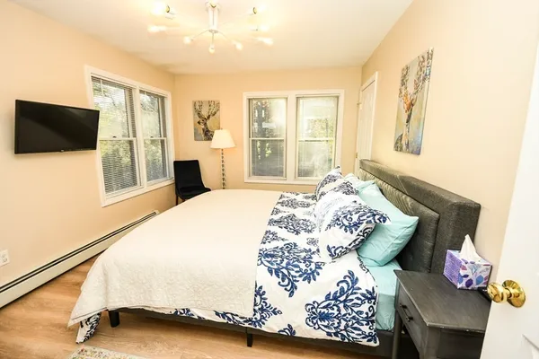 a bedroom with a bed and wooden floor