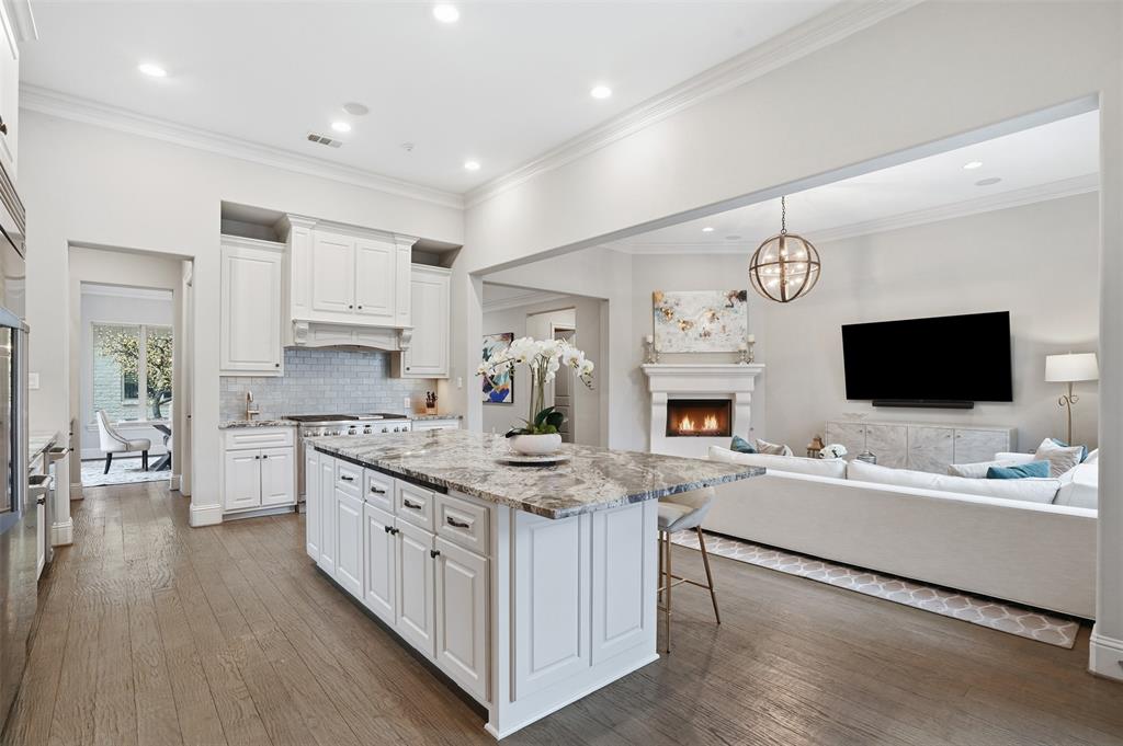 6714 Williamson Road Dallas, TX 75214 - Photo 16 of 40 a large white kitchen with a stove oven a kitchen island with the wooden floor and cabinets