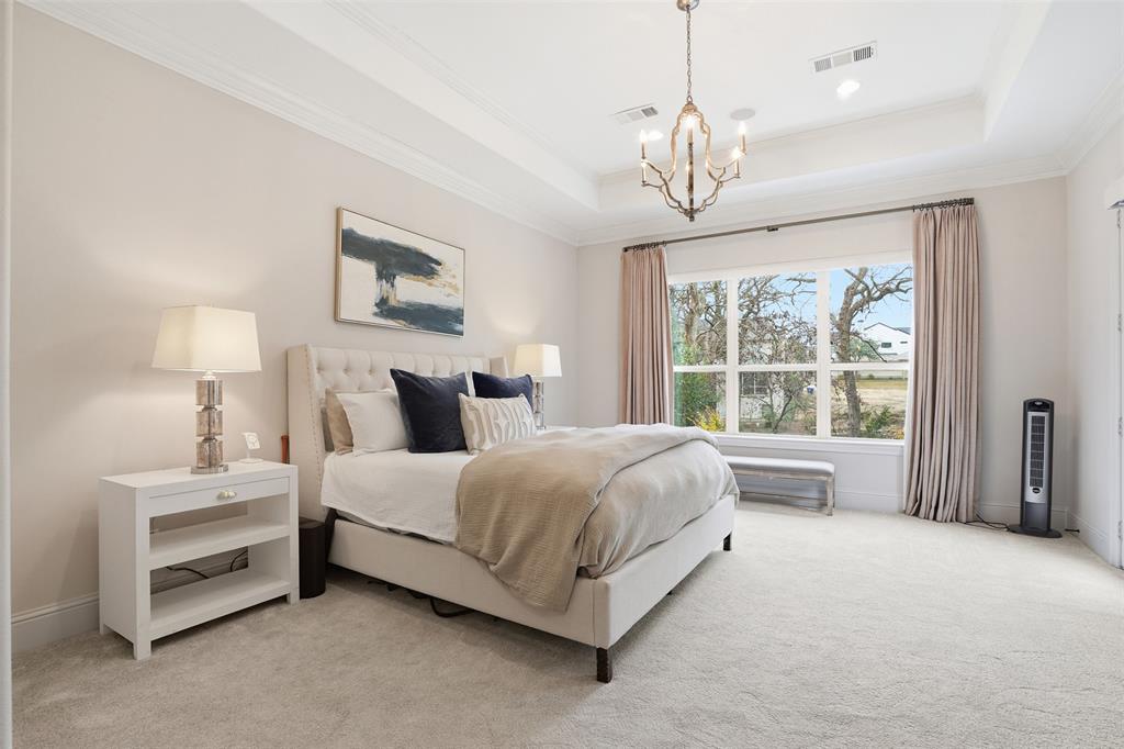 6714 Williamson Road Dallas, TX 75214 - Photo 18 of 40 a spacious bedroom with a bed chandelier and window