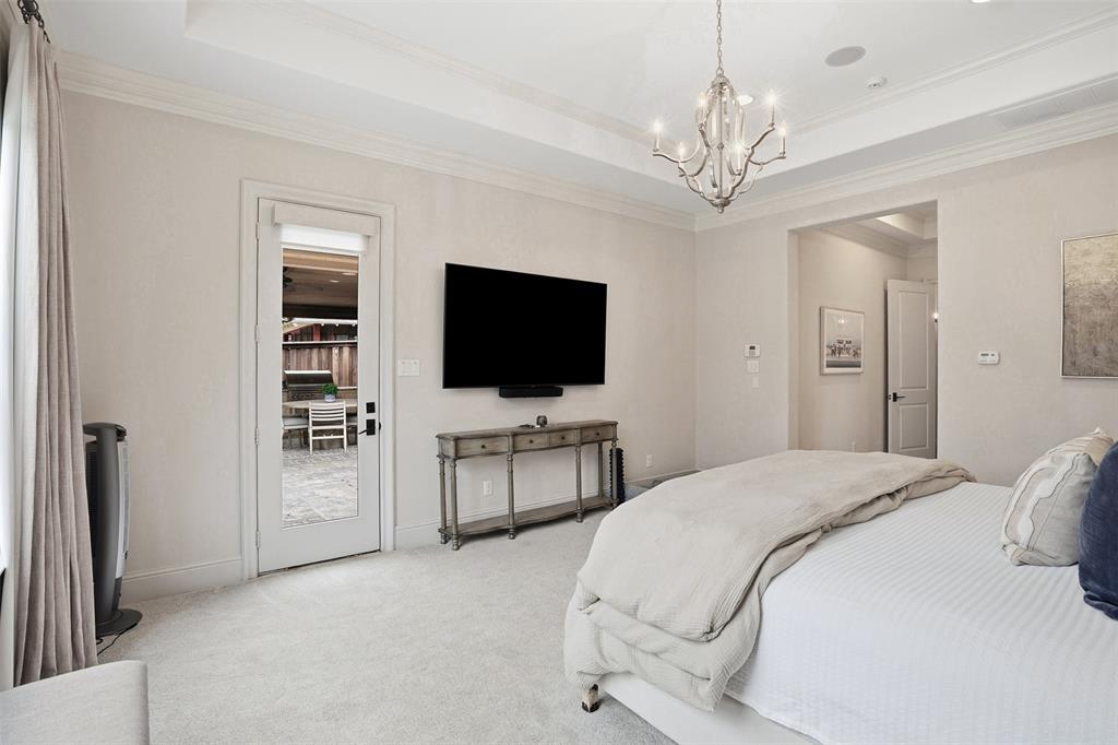 6714 Williamson Road Dallas, TX 75214 - Photo 19 of 40 a spacious bedroom with a bed and a flat screen tv