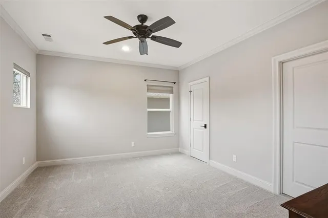 an empty room with a ceiling fan and windows