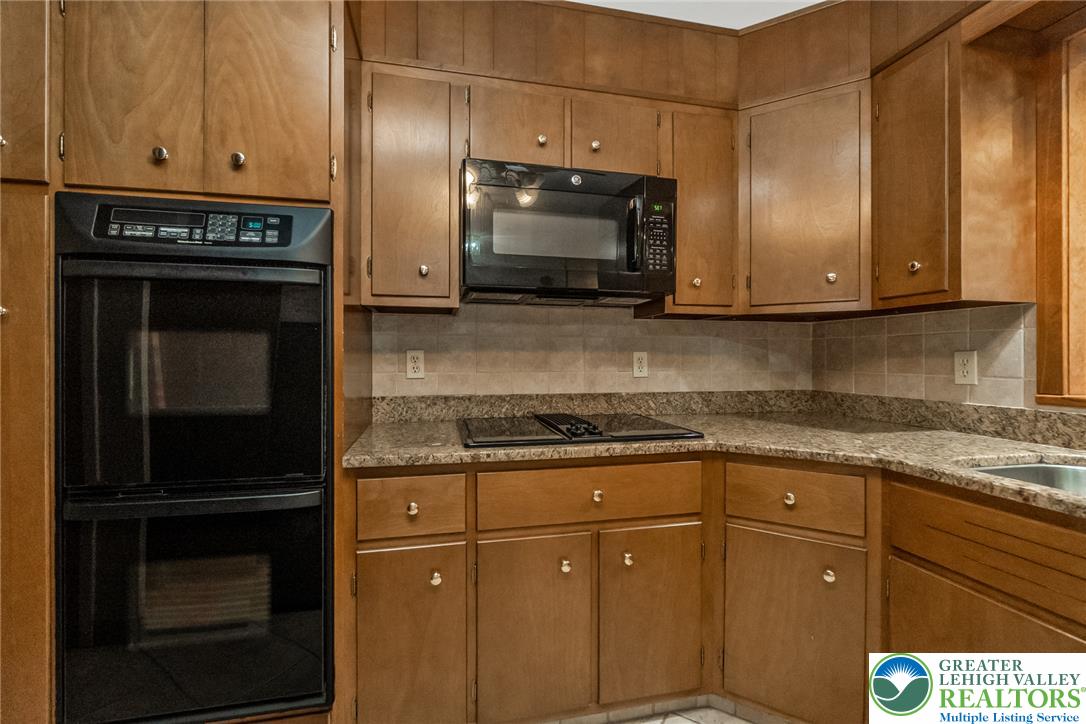 1328 Russett Road Allentown, PA 18104 - Photo 12 of 46 A well-appointed kitchen showcasing durable countertops, a built-in oven, and a microwave for effortless meal preparation.