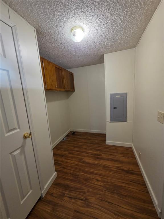 129 Bishop Road Smiths Station, AL 36877 - Photo 10 of 24 Laundry room featuring dark wood-type flooring, a textured ceiling, and electric panel