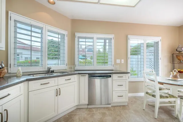 a large kitchen with kitchen island lots of counter top space a sink a stove and appliances