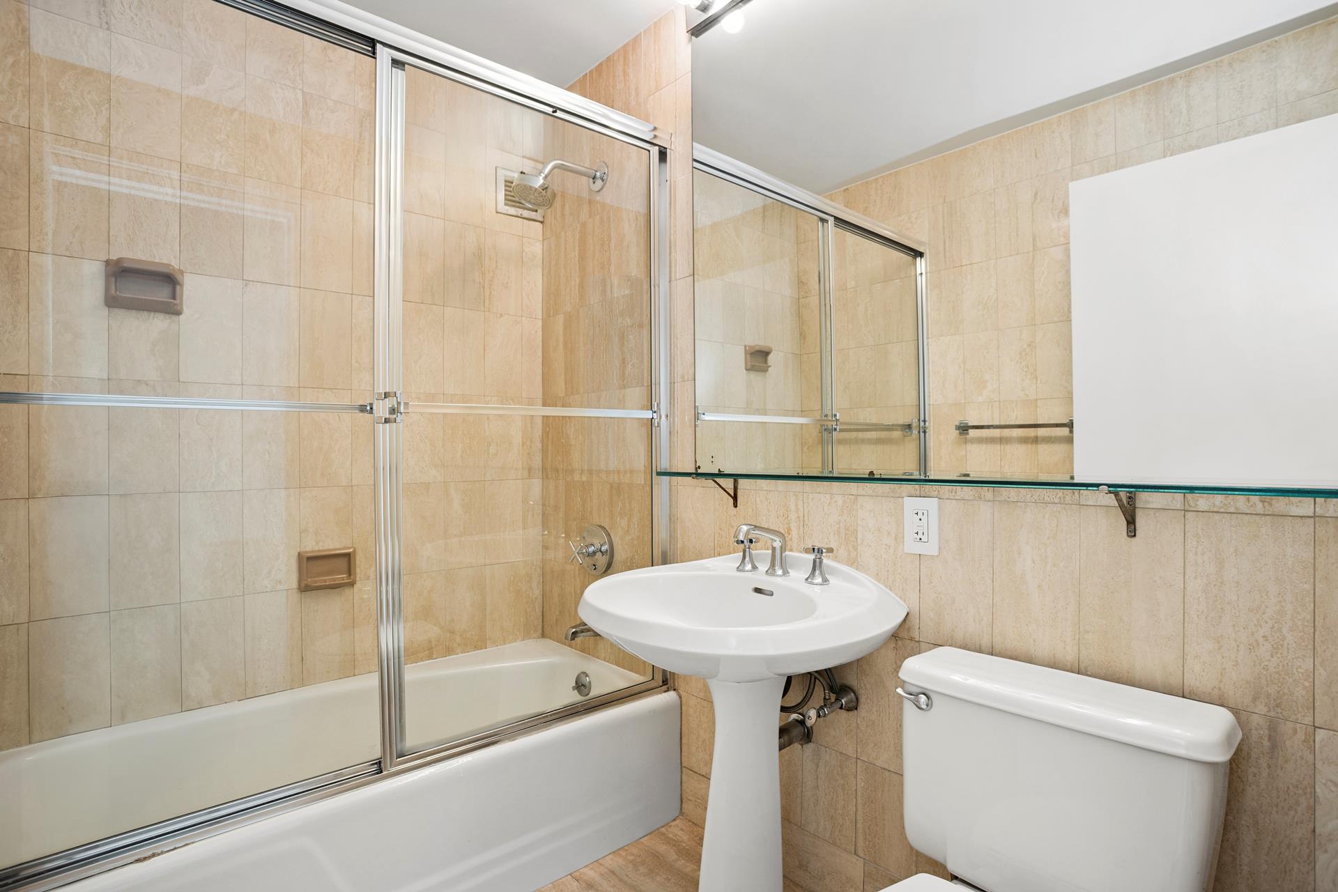 45 West 67th Street, Unit 28F Manhattan, NY 10023 - Photo 4 of 9 a bathroom with a sink a toilet and shower