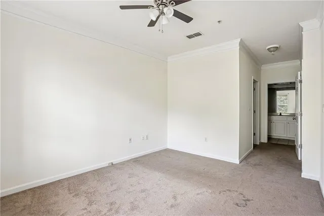 an empty room with a ceiling fan and a window