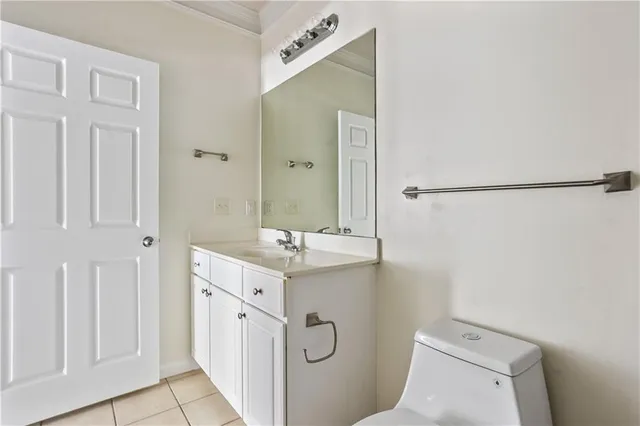 a spacious bathroom with a granite countertop sink a toilet and a mirror