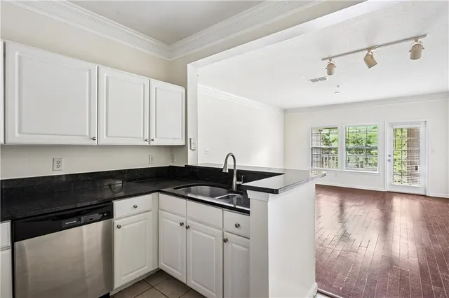 a kitchen with granite countertop white cabinets and a black appliances