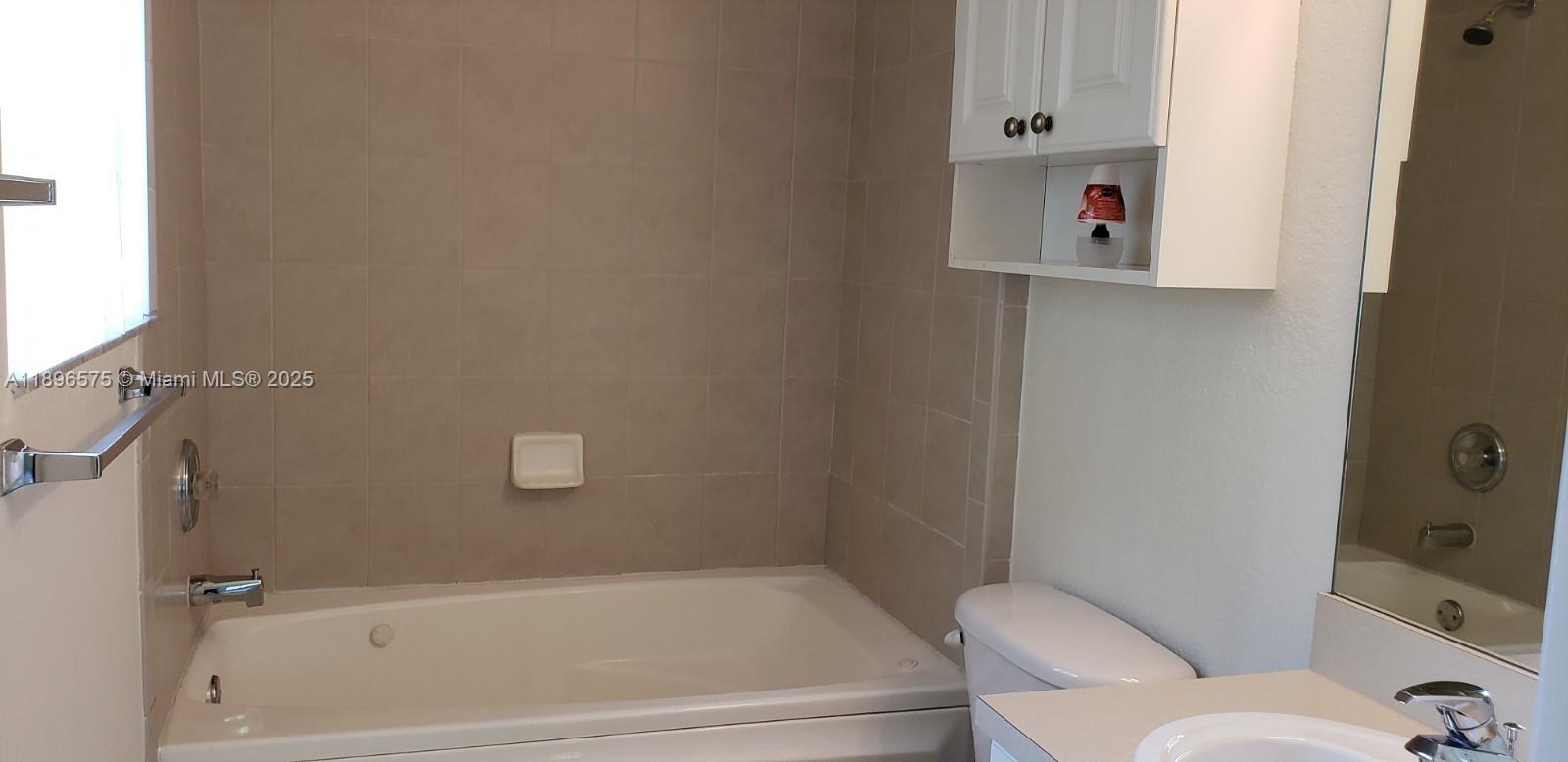 4950 Washington Street, Unit 5 Hollywood, FL 33021 - Photo 17 of 19 a bathroom with a bathtub and shower