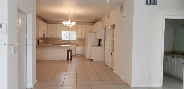 a view of a kitchen with a refrigerator and a sink