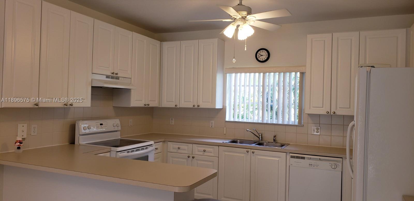 4950 Washington Street, Unit 5 Hollywood, FL 33021 - Photo 7 of 19 a kitchen with stainless steel appliances granite countertop a sink a stove and a window