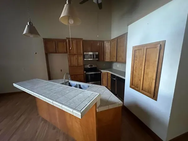 a kitchen with kitchen island wooden cabinets a refrigerator and a sink