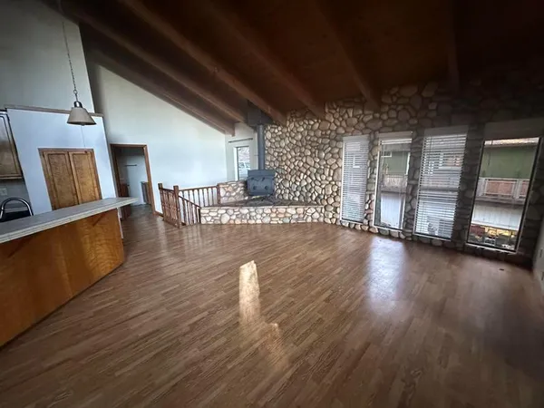 a view of a livingroom with wooden floor and furniture