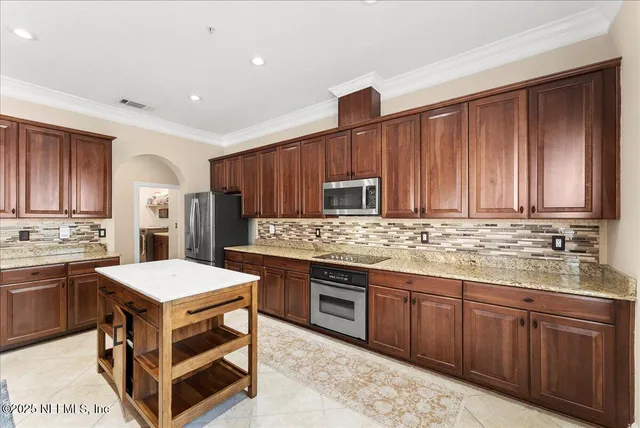a kitchen with stainless steel appliances granite countertop wooden cabinets sink and stove