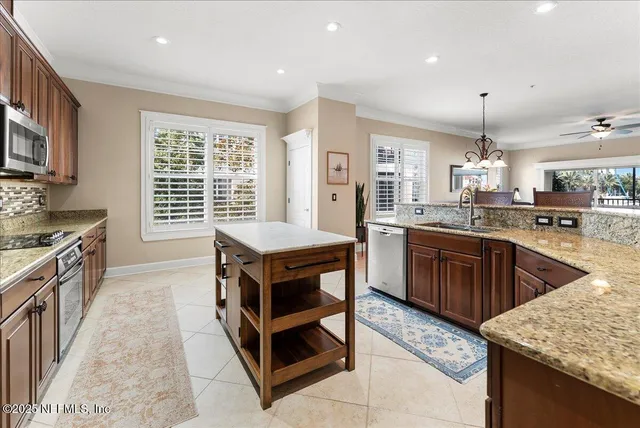 a kitchen with stainless steel appliances granite countertop a stove oven and a refrigerator with white cabinets