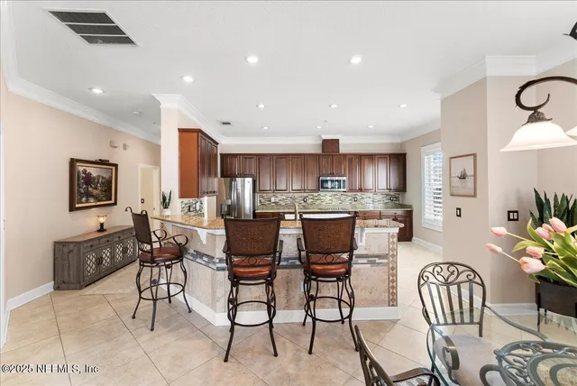 a view of a dining room and livingroom with furniture wooden floor a chandelier