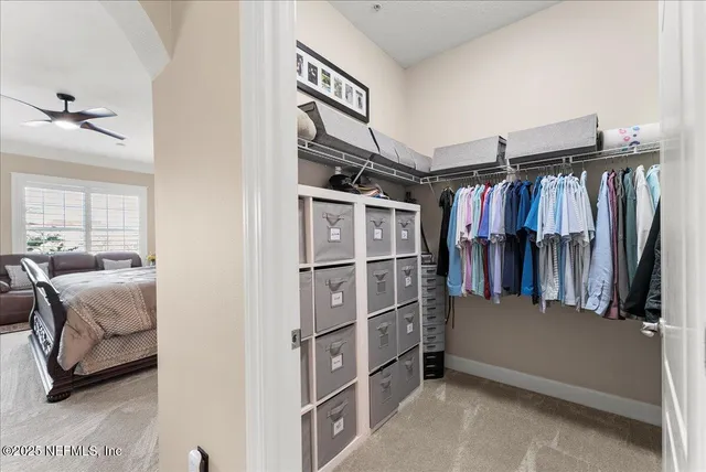 a view of walk in closet with clothes and shoes